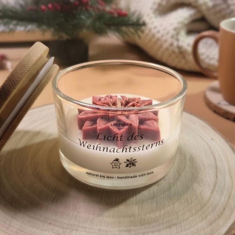 Kerze im Glas mit rotem Stern und der Aufschrift Licht des Weihnachtssterns